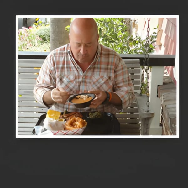 A man in a plaid shirt eats a bowl of chili with a side of BBQ at Bessinger's.