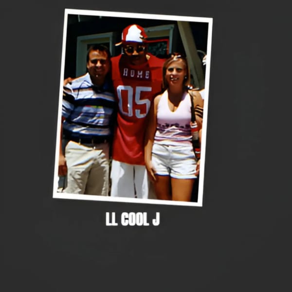 LL Cool J, wearing a red jersey and hat, poses with two fans outdoors.