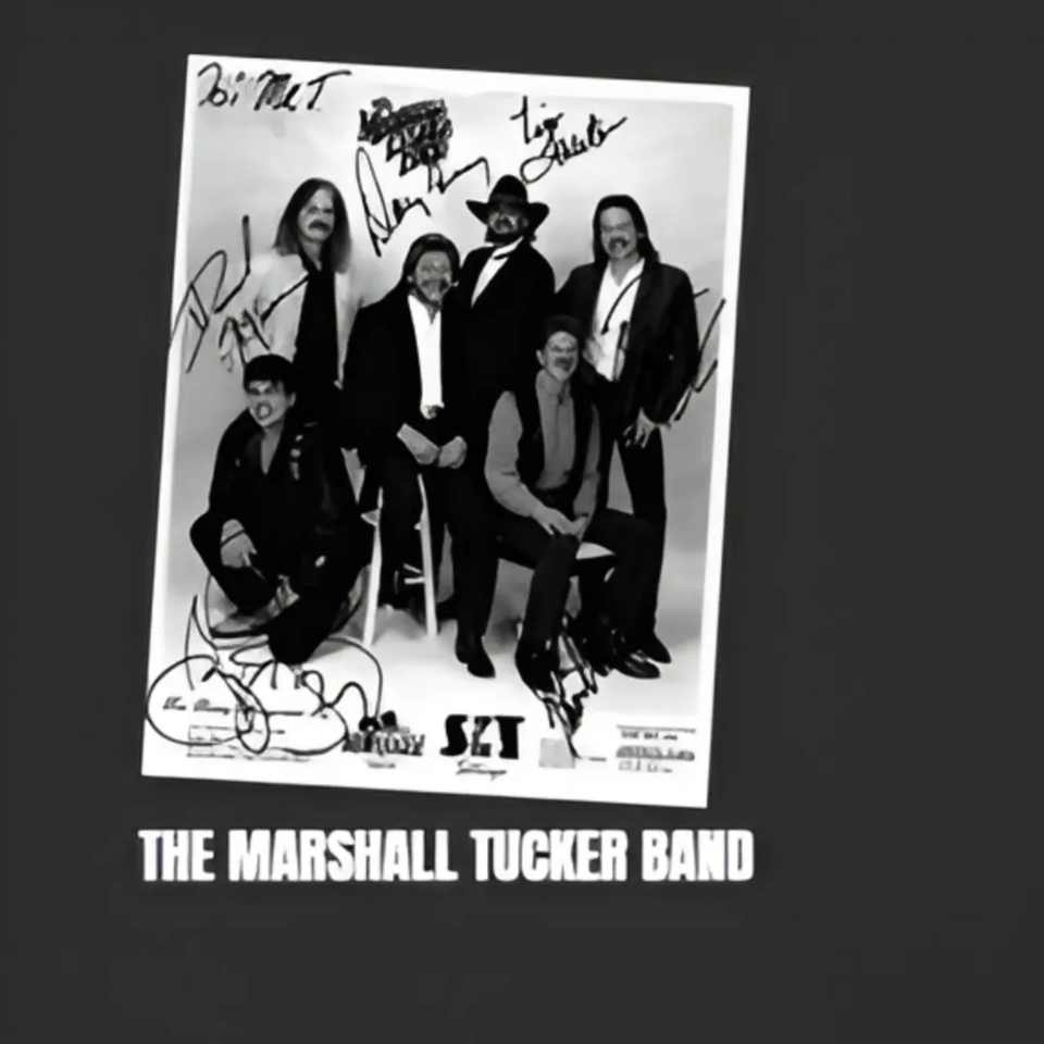 Black and white autographed photo of The Marshall Tucker Band, a group of six men.